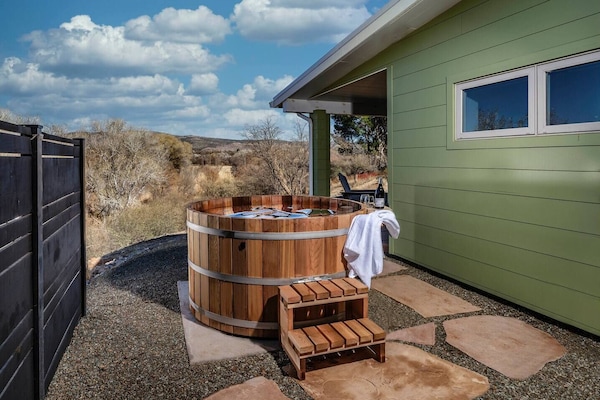 Dive into relaxation in our Northern Lights Cedar hot tub, with Oak Creek's gentle flow and House Mountain's grandeur as your backdrop. It's not just a soak; it's an escape!