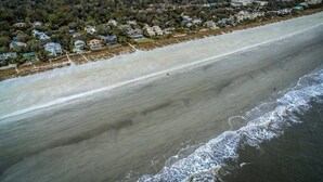 Luchtbeeld van een strand met huizen langs de kust.