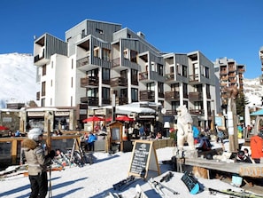 Stunning building with a flat roof and large windows, set amidst a winter wonderland.