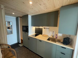 Kitchen area with sink, microwave, and cabinetry.