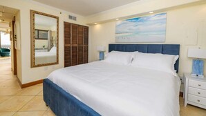 A bedroom with a large bed, a wardrobe, a mirror, and a painting on the wall. - Oceanfront Penthouse, Amazing Views, Walk to Conv Center, Attractions & Dining (Myrtle Beach)