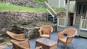 Een terras met rieten meubilair en een stenen muur.