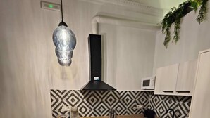 Una cucina moderna con un tavolo di legno apparecchiato per mangiare, un forno integrato e un forno a microonde.