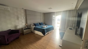 Une chambre d’hôtel moderne équipée d’un lit, d’un bureau, d’une chaise et d’un téléviseur.