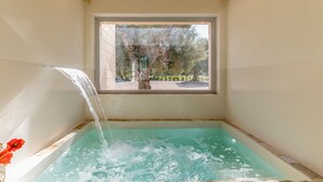 A hot tub with a view of trees and a window.