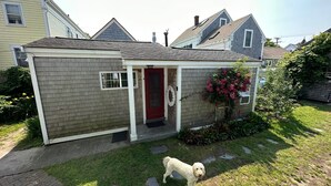 Ein kleines, eingeschossiges Haus mit roter Tür und einer überdachten Veranda.