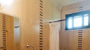 A bathroom with a round sink, a toilet, and a shower curtain.