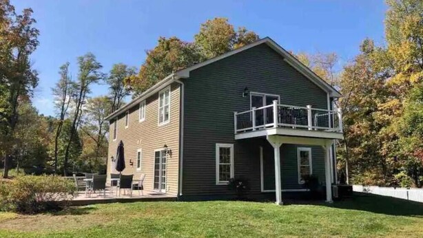 A two-story house with a balcony, a covered patio, and a lawn. - Beautiful, Spacious, 5 Acre Hudson Valley Family Retreat (Poughkeepsie)