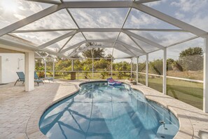 A covered swimming pool with a view of the surrounding landscape.