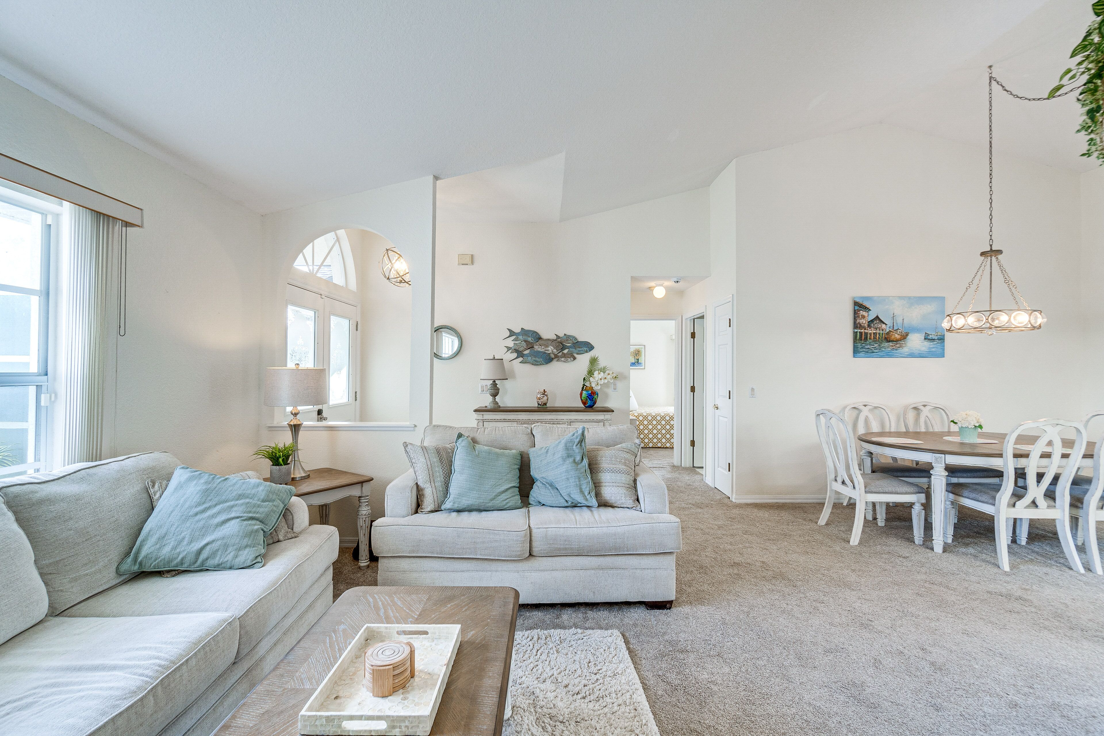 A spacious living room with a sofa, a coffee table, and a dining area with a table and chairs.