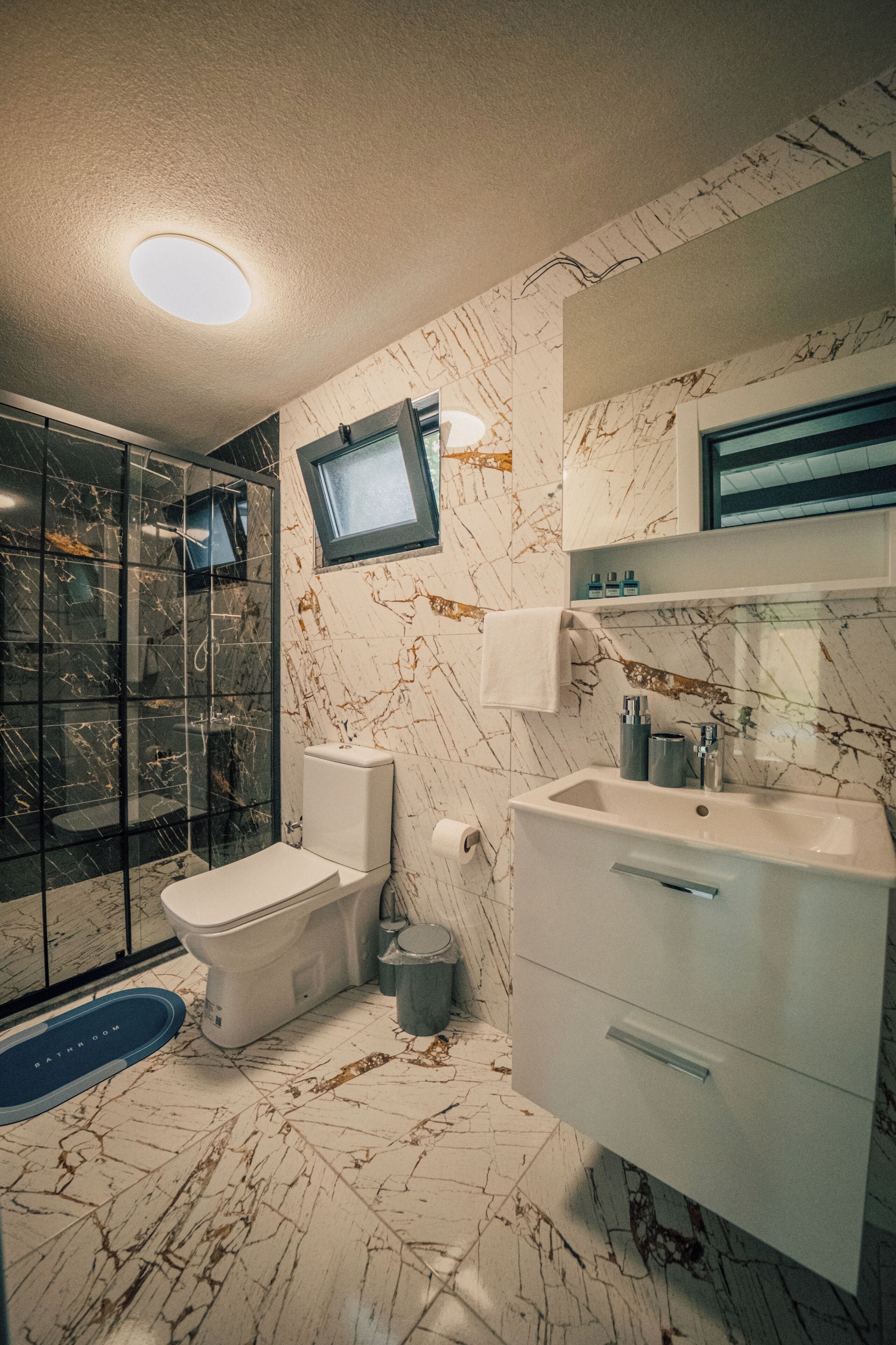 Un baño con inodoro, lavabo y zona de ducha.