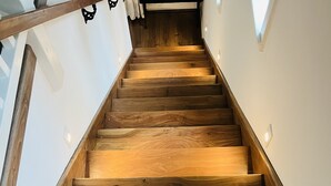 A wooden staircase with a modern design, leading to a higher floor.