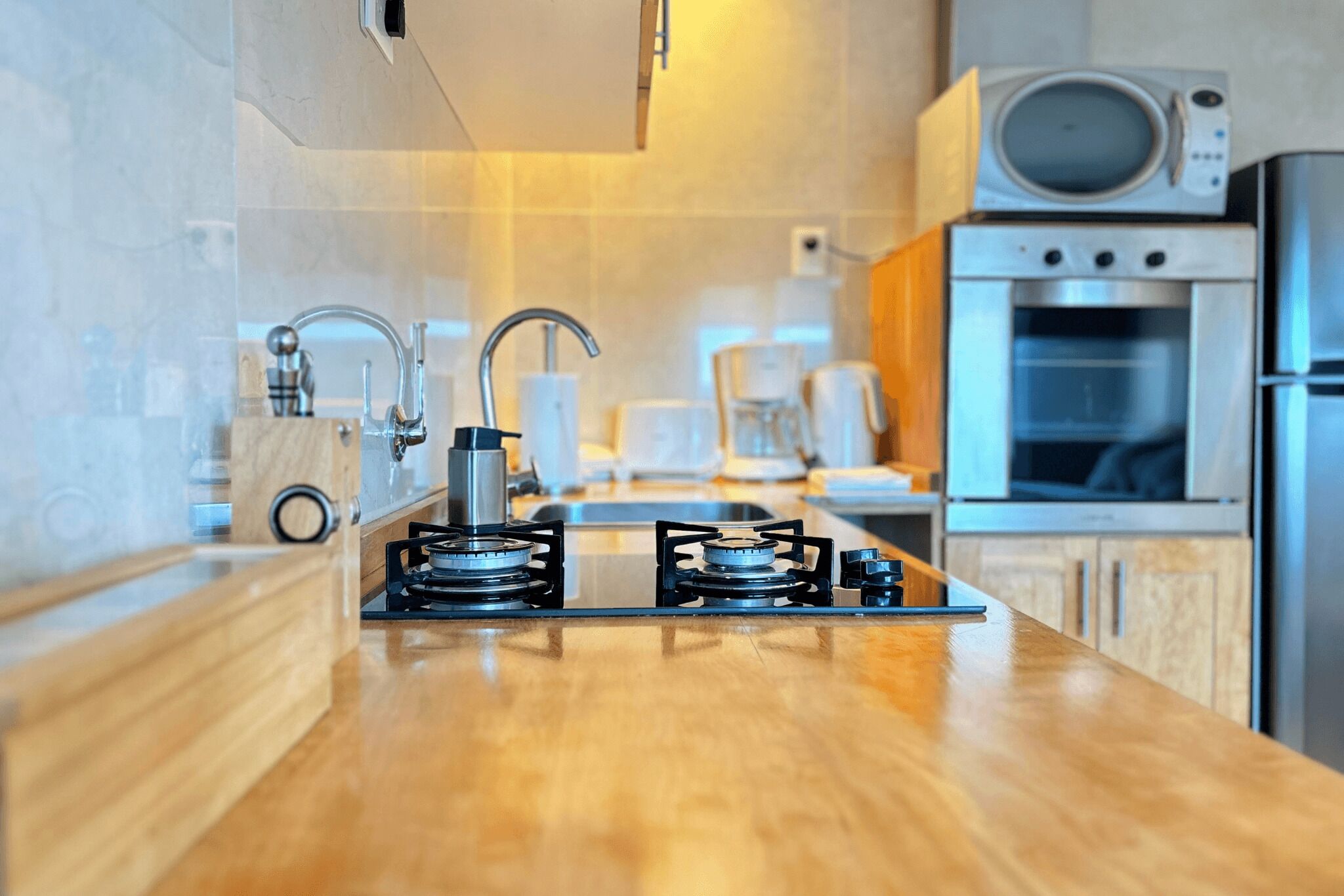 Una cocina moderna con estufa a gas, microondas y horno.