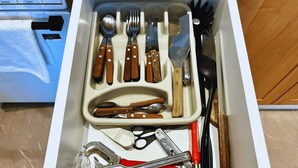 A drawer with various kitchen utensils including spoons, forks, knives, and scissors. - Studio in Bariloche for two people (San Carlos de Bariloche)