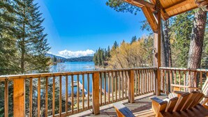 A wooden deck with a view of a lake and mountains. - Amazing Lakefront Getaway-sleeps 18 guests, w/private dock, gameroom, spa & more (Hayden)