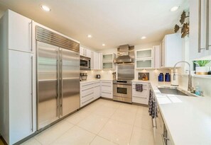 A modern kitchen with stainless steel appliances, white cabinetry, and a central island. - Lakeside | Private Pool | Sleeps 18 | Dog-Friendly (Hot Springs)