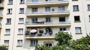 A multi-story residential building with balconies, a sign indicating private property, and lush greenery in the foreground. - Appartement Rénové Avec Place de Parking Dans Résidence Fermée et Sécurisée (Gières)