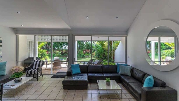 A modern living room with a sectional sofa, a coffee table, and a fireplace. - Port Douglas Mirage Villa#423 (Port Douglas)