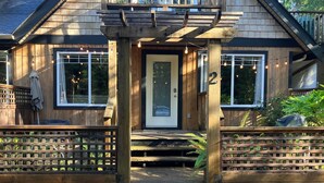 Une maison en bois avec un porche à l’avant, une porte et le numéro « 2 » sur la porte.