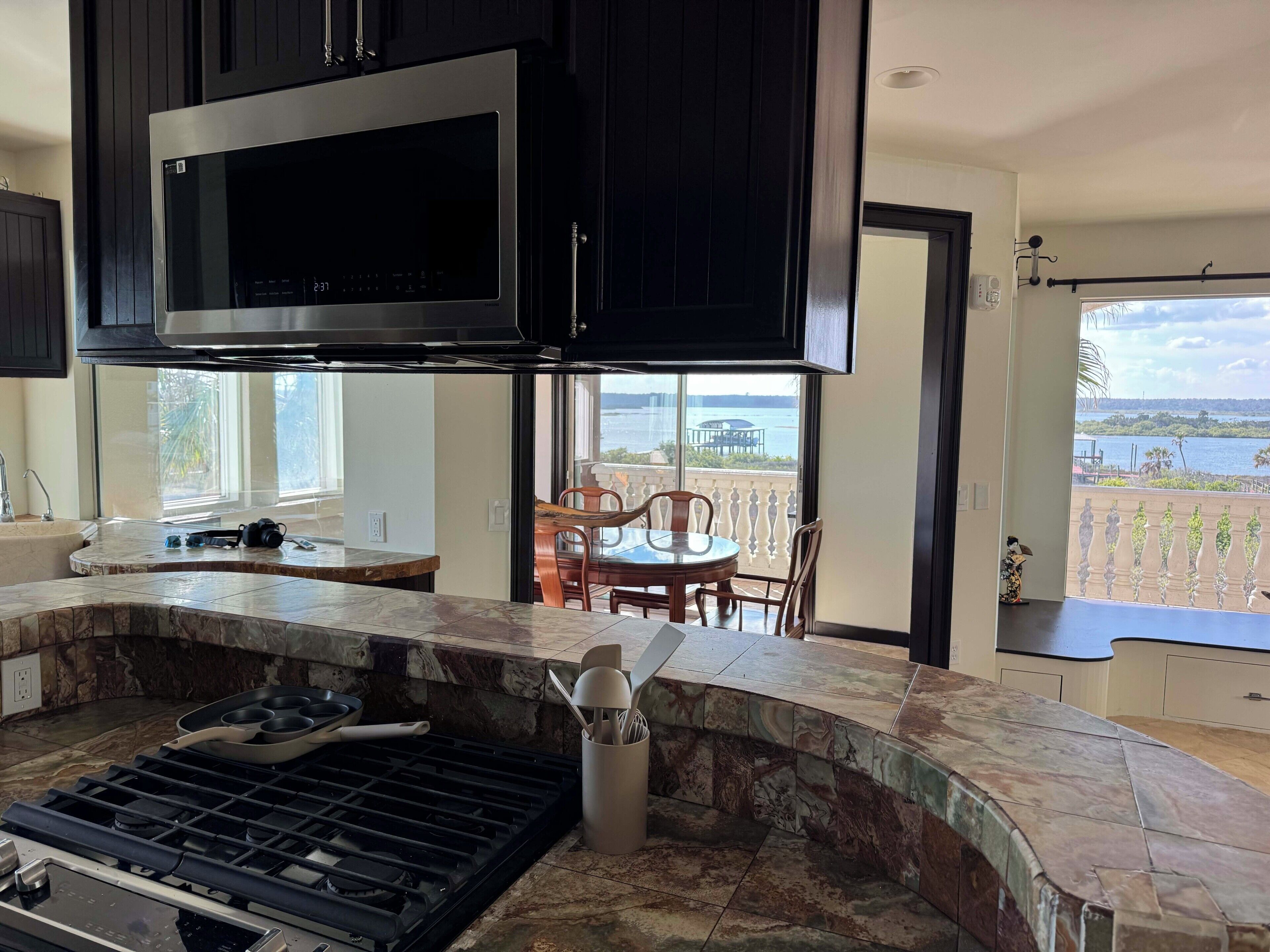 A modern kitchen with a built-in grill, a large window, and a view of the outdoors.