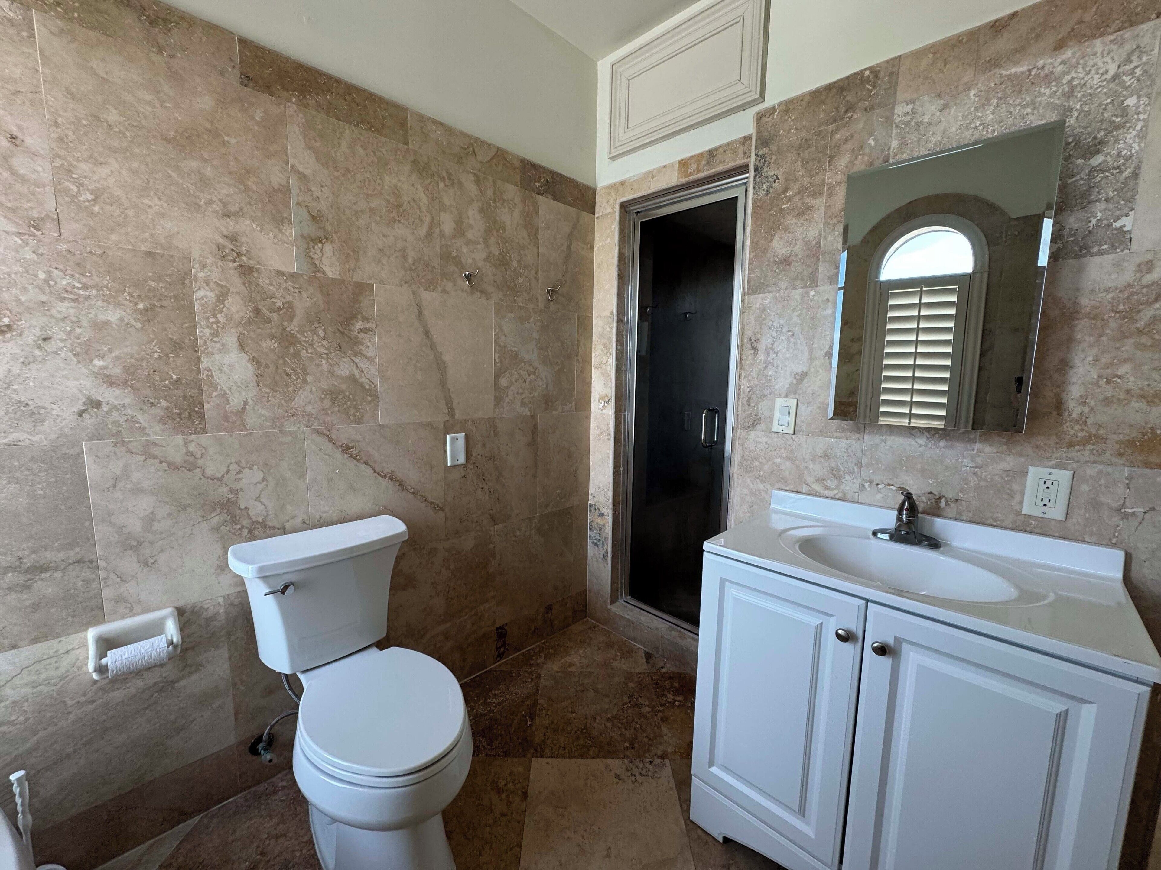A bathroom with a toilet, sink, and shower.