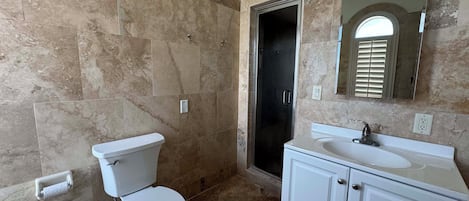 Un baño con inodoro, lavamanos y ducha.