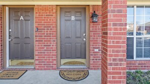 A two-door entrance with 'A' and 'B' labels, a doormat, and a welcome mat. - Cozy 3-bedroom Townhome in Charming Killeen With WiFi, AC (Killeen)