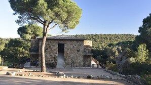 A stone building with a tiled roof, a staircase leading to a balcony, and a large tree in front. - Apartment 'Luna Verde' with Shared Pool, Private Terrace and Wi-Fi (Porto-Vecchio)