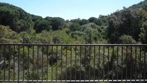 A balcony with a metal railing overlooking a forested hillside. - Apartment 'Luna Verde' with Shared Pool, Private Terrace and Wi-Fi (Porto-Vecchio)