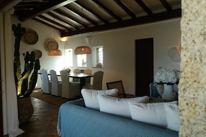 A dining area with a table, chairs, and a cactus plant. - Villa 'Acula' with Sea View, Wi-Fi and Air Conditioning (Cannigione)