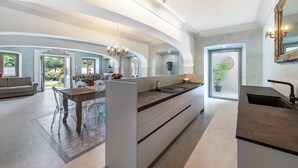 Una cocina moderna con una isla central, electrodomésticos integrados y un espejo grande.