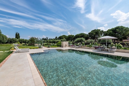 A clear swimming pool with lounge chairs and a garden area.. Apartment 'Abaye 6 Cabernet - Charm' with Shared Pool, Wi-Fi and Air Conditioning