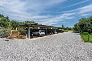 A covered parking area with a gravel driveway, a staircase, and a car parked under the shelter. - Apartment 'Abaye 4 Merlot - Charm' with Shared Pool, Wi-Fi and Air Conditioning (Soiano del Lago)