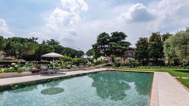 A clear swimming pool with lounge chairs and a covered seating area. - Holiday Home 'Abaye 3 Chianti Charm' with Lake View, Wi-Fi and Air Conditioning (Soiano del Lago)