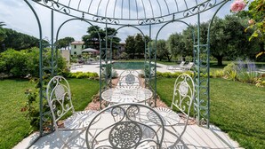 A gazebo with a metal roof and ornate metalwork, surrounded by a well-maintained garden with various plants and a lawn. - Holiday Home 'Abaye 3 Chianti Charm' with Lake View, Wi-Fi and Air Conditioning (Soiano del Lago)