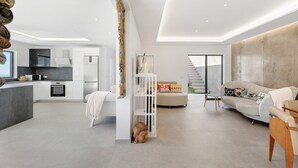 Een moderne woonruimte met een keuken, een bank en een trap.