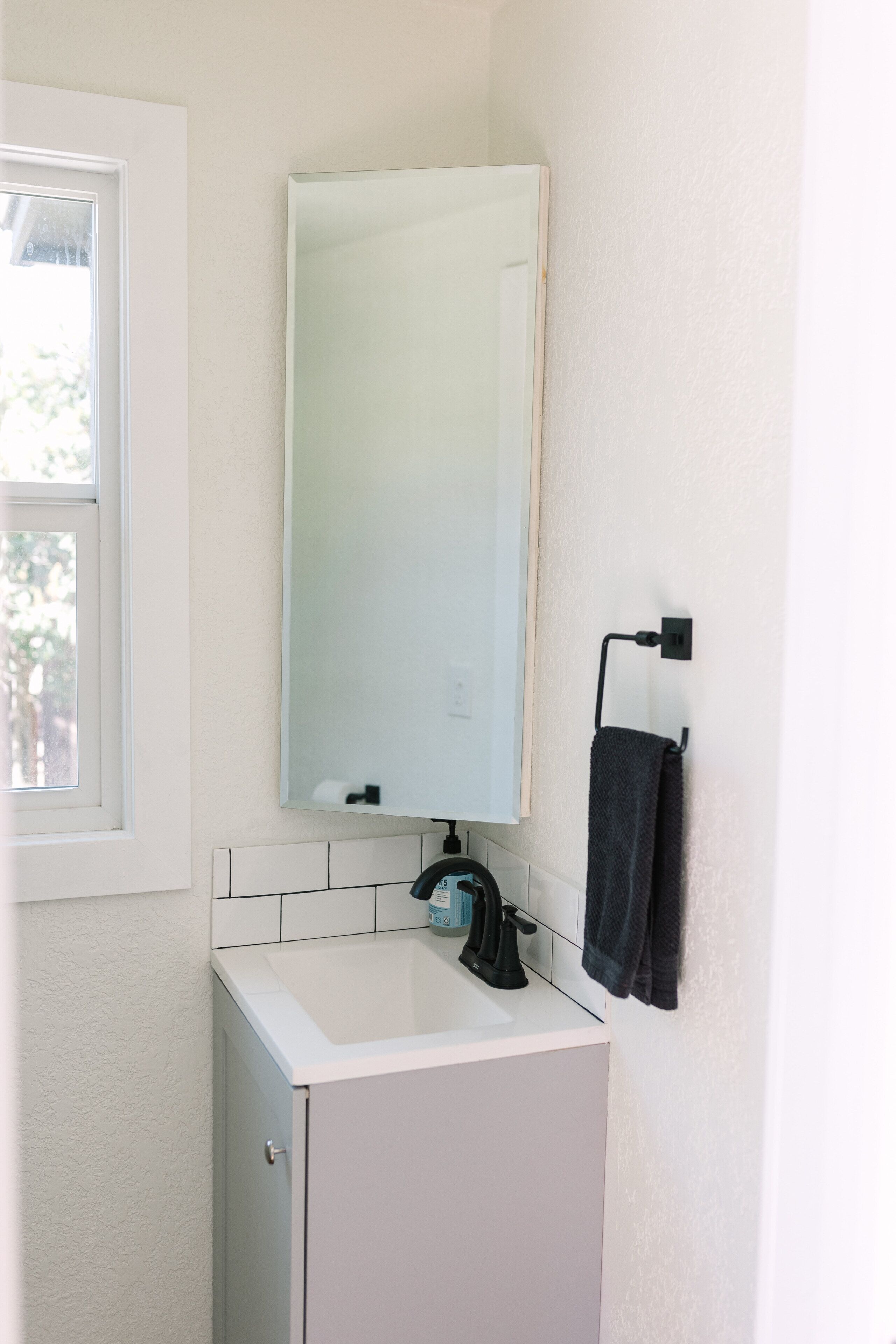 Ein Badezimmer mit Waschbecken, Spiegel und Handtuchhalter.