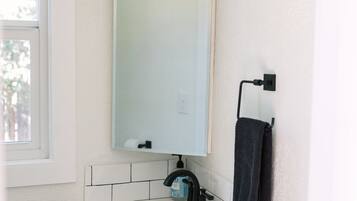 Ein Badezimmer mit Waschbecken, Spiegel und Handtuchhalter.