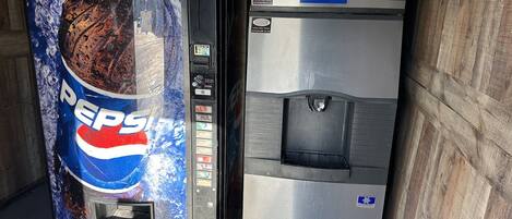 Una máquina expendedora y un refrigerador de acero inoxidable.