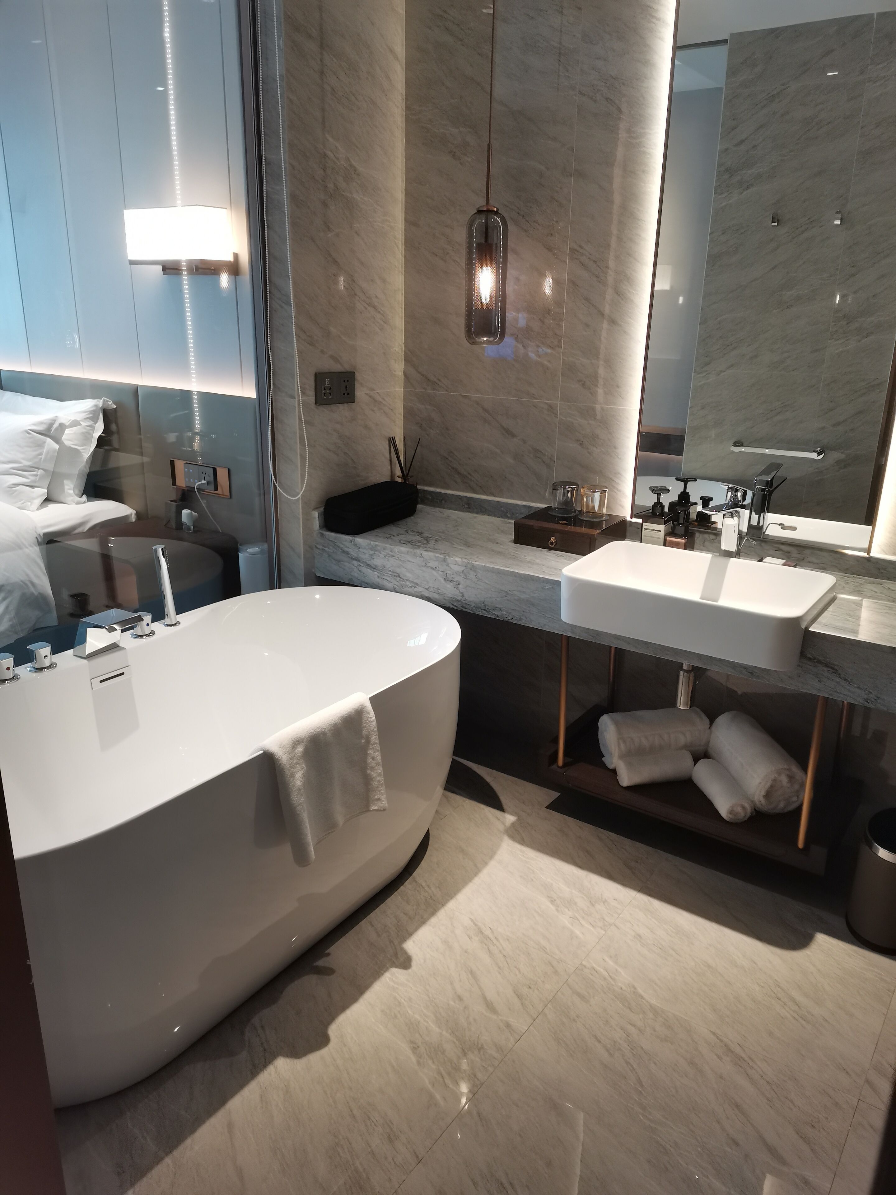 A modern bathroom with a large bathtub, a vanity with a mirror, and a towel rack.