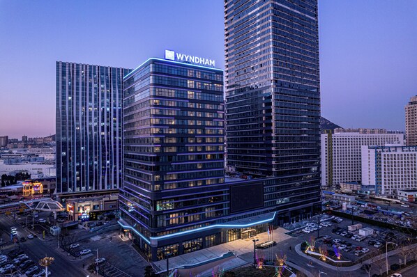 Un edificio moderno de gran altura con el nombre 'WYNDHAM' en la parte superior.