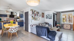 Un appartement moderne comprenant un coin repas, un canapé, une bibliothèque et une cuisine.
