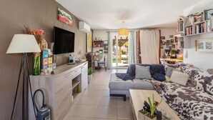 Un salon moderne avec un canapé, un téléviseur et un coin repas.