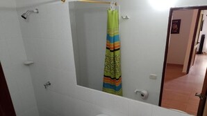 A bathroom with a toilet, sink, shower, and a mirror. - Finca hotel Sendero del rio (San Rafael)
