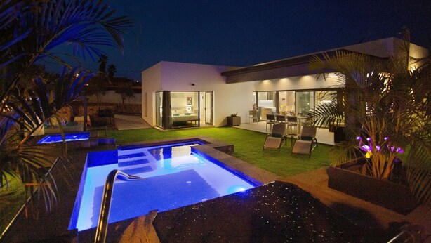 A modern house with a swimming pool, outdoor furniture, and a well-lit interior. - Laian Branded Residensed House with Private Pool and Air Conditioning (Triquivijate)