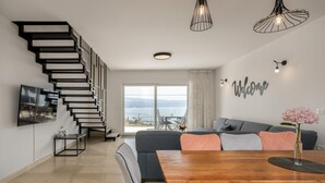 Un espace de vie moderne comprenant un escalier, un coin repas et un ensemble de canapés.