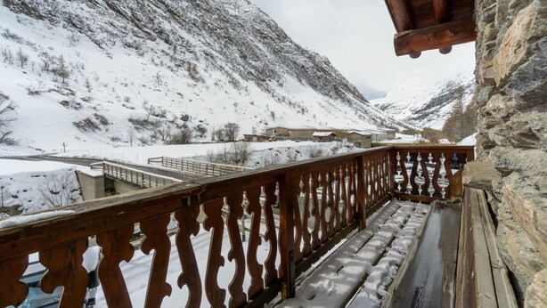 Et sneklædt bjerglandskab med gelænder af træ.