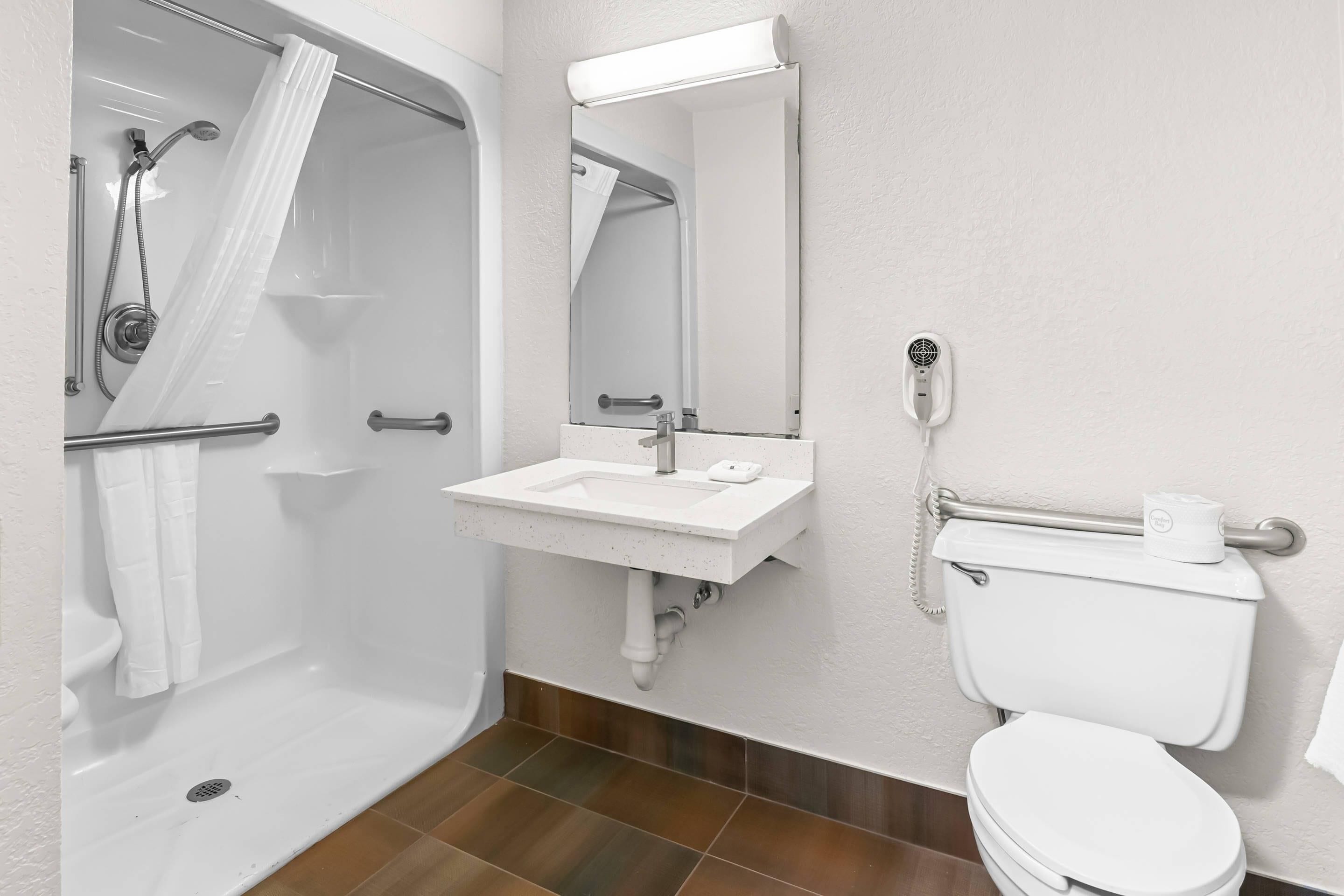 Une salle de bain équipée d’une douche, d’un lavabo, de toilettes et d’un miroir.