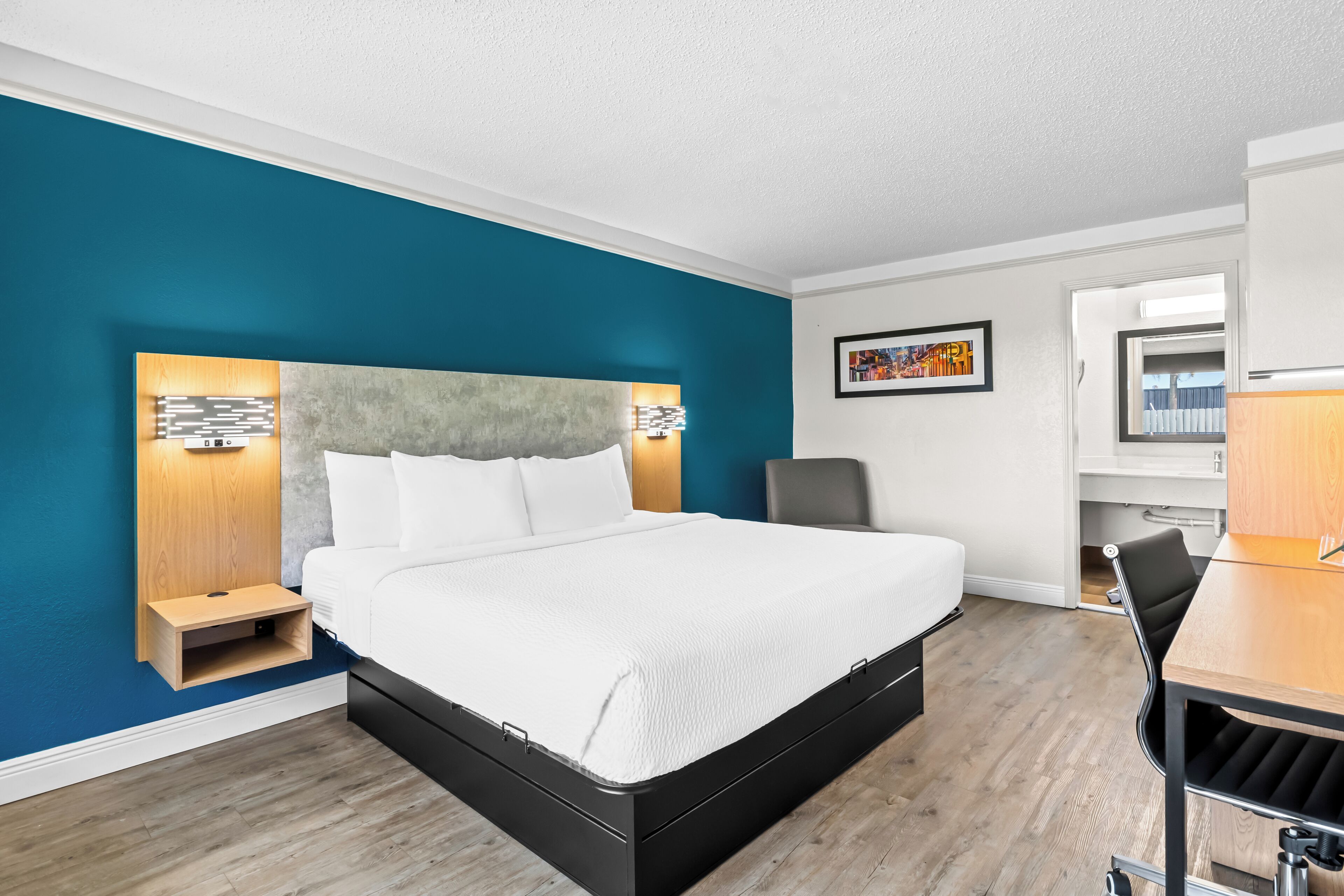 Una habitación de hotel moderna con una cama grande, un escritorio y una silla.