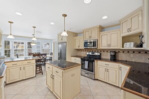 A spacious kitchen with a central island, stainless steel appliances, and light-colored cabinetry.